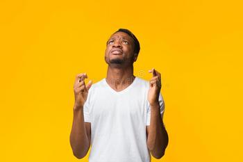 superstitious-african-american-man-keeping-fingers-crossed-making-wish-asking-something-standing-over-yellow-studio-169287206.jpg